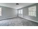 Spacious carpeted bedroom with two windows and white trim throughout at 1885 Vintage Dr, Snellville, GA 30078