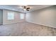 Large bedroom with plush carpet, ceiling fan, two windows and neutral paint scheme at 1885 Vintage Dr, Snellville, GA 30078