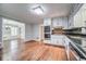 Open kitchen with stainless appliances, tile backsplash, and hardwood floors leading to dining room at 1885 Vintage Dr, Snellville, GA 30078