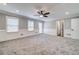 Spacious living room featuring a ceiling fan, neutral paint, plush carpeting, and great natural light at 1885 Vintage Dr, Snellville, GA 30078