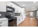 Modern kitchen featuring sleek white cabinets, black hardware, and black appliances at 208 Silver Springs Sw Cir, Atlanta, GA 30310