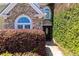 Stone accented entry with dark wooden door and mature landscaping at 2103 Drogheda Ln, Marietta, GA 30066