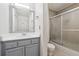 Bathroom features a gray vanity with framed mirror and frosted glass enclosed shower-tub combination at 3980 Riverlook Se Pkwy # 203, Marietta, GA 30067