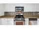 Kitchen area featuring gas range, stainless appliances, granite counters, and tile backsplash at 3980 Riverlook Se Pkwy # 203, Marietta, GA 30067