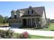 Traditional two-story home with a two-car garage, dormer windows and a beautifully landscaped lawn at 1213 Dawnview Dr, Locust Grove, GA 30248