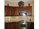 A kitchen with wooden cabinetry, updated appliances, and neutral-toned countertops with tile backsplash at 1213 Dawnview Dr, Locust Grove, GA 30248