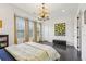Spacious bedroom with light-filled windows, a modern chandelier, and sleek dark floors at 215 Britten Pass, Alpharetta, GA 30009
