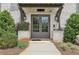 A welcoming brick building entrance featuring modern double doors and manicured greenery at 215 Britten Pass, Alpharetta, GA 30009
