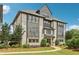 Beautiful brick condo building with manicured lawn and walkway to entrance on a sunny day at 215 Britten Pass, Alpharetta, GA 30009