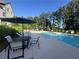 Relaxing community pool area features lounge chairs, umbrella-covered tables, and mature landscaping at 215 Britten Pass, Alpharetta, GA 30009