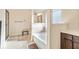 Bright bathroom featuring a soaking tub, tiled floors, and a dark wood vanity at 4058 Rosebay Way, Conyers, GA 30094