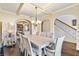 Formal dining room with coffered ceiling, elegant chandelier, and view to the living room and stairs at 4058 Rosebay Way, Conyers, GA 30094