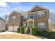 Charming brick home with a two-car garage, manicured shrubs, and a stylish front entrance at 4058 Rosebay Way, Conyers, GA 30094