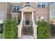 Inviting front entrance with decorative columns, lush greenery, and a stylish front door at 4058 Rosebay Way, Conyers, GA 30094