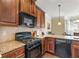 Kitchen area featuring black appliances, granite countertops, and wood cabinets at 4058 Rosebay Way, Conyers, GA 30094