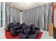 Home movie theater room with black leather seats, a red carpet, and luxurious silver curtains at 4058 Rosebay Way, Conyers, GA 30094
