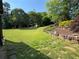 Expansive backyard with lush lawn, mature trees, and thoughtfully landscaped garden beds at 5403 Timber Wild Ln, Buford, GA 30518