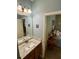 Bathroom featuring a granite countertop vanity, decorative mirror, and great lighting at 5403 Timber Wild Ln, Buford, GA 30518