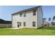 Expansive backyard featuring the home's rear elevation and lush green lawn on a sunny day at 89 Citadel Dr, Hampton, GA 30228