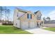 Angle side view of the house showcasing the garage, lawn, and architectural details at 89 Citadel Dr, Hampton, GA 30228