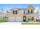 Charming two-story home featuring a brick and siding exterior, a two-car garage, and a manicured front lawn at 89 Citadel Dr, Hampton, GA 30228