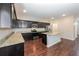 Modern kitchen featuring dark cabinetry, granite countertops, stainless steel appliances, and a central island at 89 Citadel Dr, Hampton, GA 30228