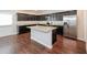 Spacious kitchen with dark wood cabinets, granite countertops, a center island, and stainless steel appliances at 89 Citadel Dr, Hampton, GA 30228
