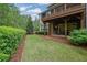Beautiful backyard with a covered patio, green grass, and lush landscaping at 125 Windy Pines Pass, Roswell, GA 30075