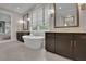 Bright bathroom featuring a soaking tub with dark wood cabinetry and patterned wallpaper at 125 Windy Pines Pass, Roswell, GA 30075
