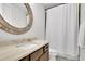 Bathroom featuring a granite countertop, wood-trimmed mirror, and shower-tub combination at 125 Windy Pines Pass, Roswell, GA 30075