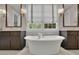 Bright bathroom featuring a soaking tub with dark wood cabinetry and large mirrors at 125 Windy Pines Pass, Roswell, GA 30075