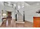 Staircase and foyer featuring hardwood floors, white wainscoting, and dark brown front door at 125 Windy Pines Pass, Roswell, GA 30075