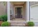 Welcoming front entrance with brick steps, columns, and a bench, leading to a dark brown front door at 125 Windy Pines Pass, Roswell, GA 30075