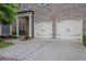 Lovely brick home with a two-car garage, featuring arched doorways and concrete driveway and walkway at 125 Windy Pines Pass, Roswell, GA 30075