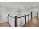 Bright hallway featuring dark wood floors and black and white banister at 125 Windy Pines Pass, Roswell, GA 30075