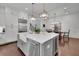 A gourmet kitchen featuring a large island, farmhouse sink, and stainless steel appliances and modern lighting at 125 Windy Pines Pass, Roswell, GA 30075