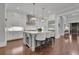 Bright kitchen with white cabinets, a large island with seating, hardwood floors, and stainless steel appliances at 125 Windy Pines Pass, Roswell, GA 30075