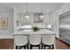 Open kitchen with a large island, breakfast bar, stainless steel appliances, and modern lighting at 125 Windy Pines Pass, Roswell, GA 30075