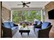 Relaxing screened porch featuring comfortable seating, ceiling fan, and an outdoor dining area with a great view at 125 Windy Pines Pass, Roswell, GA 30075