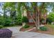 Brick home featuring a long driveway with mature trees and a well-maintained lawn at 1720 Greystone Trce, Conyers, GA 30013