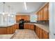Open kitchen with tile floors, lots of wooden cabinets, and modern pendant lights at 1720 Greystone Trce, Conyers, GA 30013
