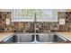 Close up of a stainless steel dual-basin kitchen sink with tile backsplash at 1720 Greystone Trce, Conyers, GA 30013