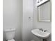 Simple powder room features a pedestal sink, toilet, mirror, and neutral paint, perfect for guests at 1720 Greystone Trce, Conyers, GA 30013