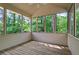 Relaxing screened porch with wooden floor, multiple windows, and tranquil wooded backyard view at 1720 Greystone Trce, Conyers, GA 30013