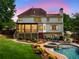 The rear exterior reveals a screened porch, manicured lawn, and a pool with a built-in spa at 4235 Night Sky Ln, Cumming, GA 30041