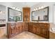 Spacious bathroom featuring a double vanity with granite counters and classic wood cabinetry at 4235 Night Sky Ln, Cumming, GA 30041