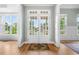 Elegant foyer featuring double glass doors, hardwood floors, and abundant natural light from surrounding windows at 4235 Night Sky Ln, Cumming, GA 30041