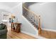 Hallway featuring stairs with iron spindles and hardwood floors, with a glimpse into the modern kitchen at 4235 Night Sky Ln, Cumming, GA 30041