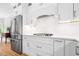 Contemporary kitchen featuring stainless steel appliances, white cabinets, and a marble backsplash at 4235 Night Sky Ln, Cumming, GA 30041