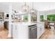 Open kitchen with a center island, stainless steel dishwasher, and view into the living and dining areas at 4235 Night Sky Ln, Cumming, GA 30041